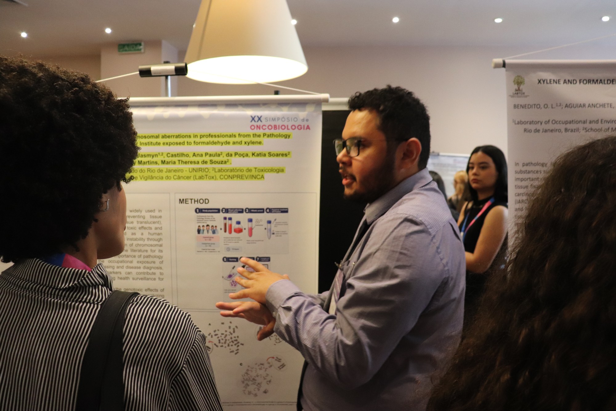 Apresentação e discussão de trabalho em uma sessão de pôsteres do XX Simpósio de Oncobiologia