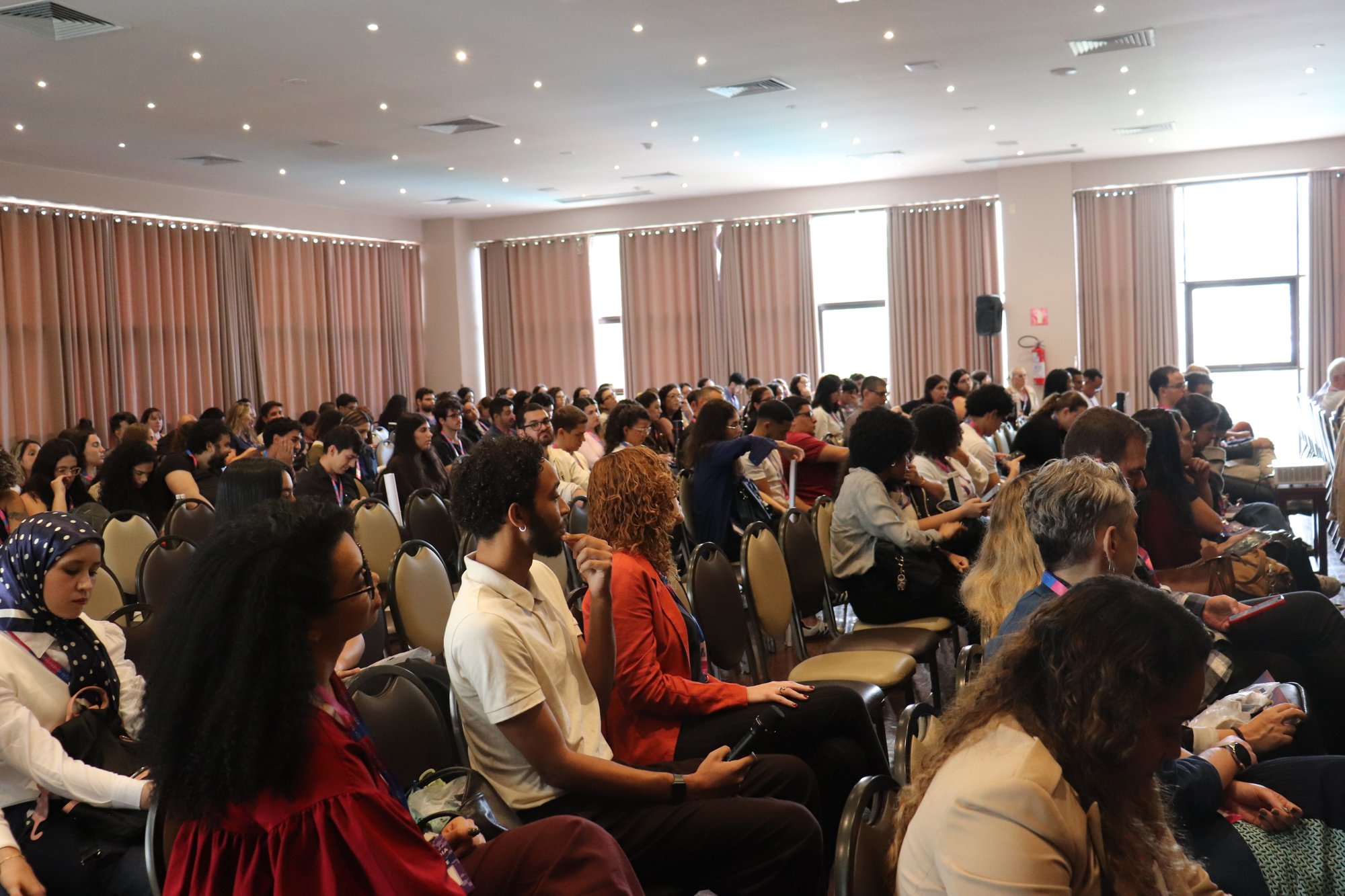 Plateia do XX Simpósio de Oncobiologia acompanhando uma palestra no auditório.